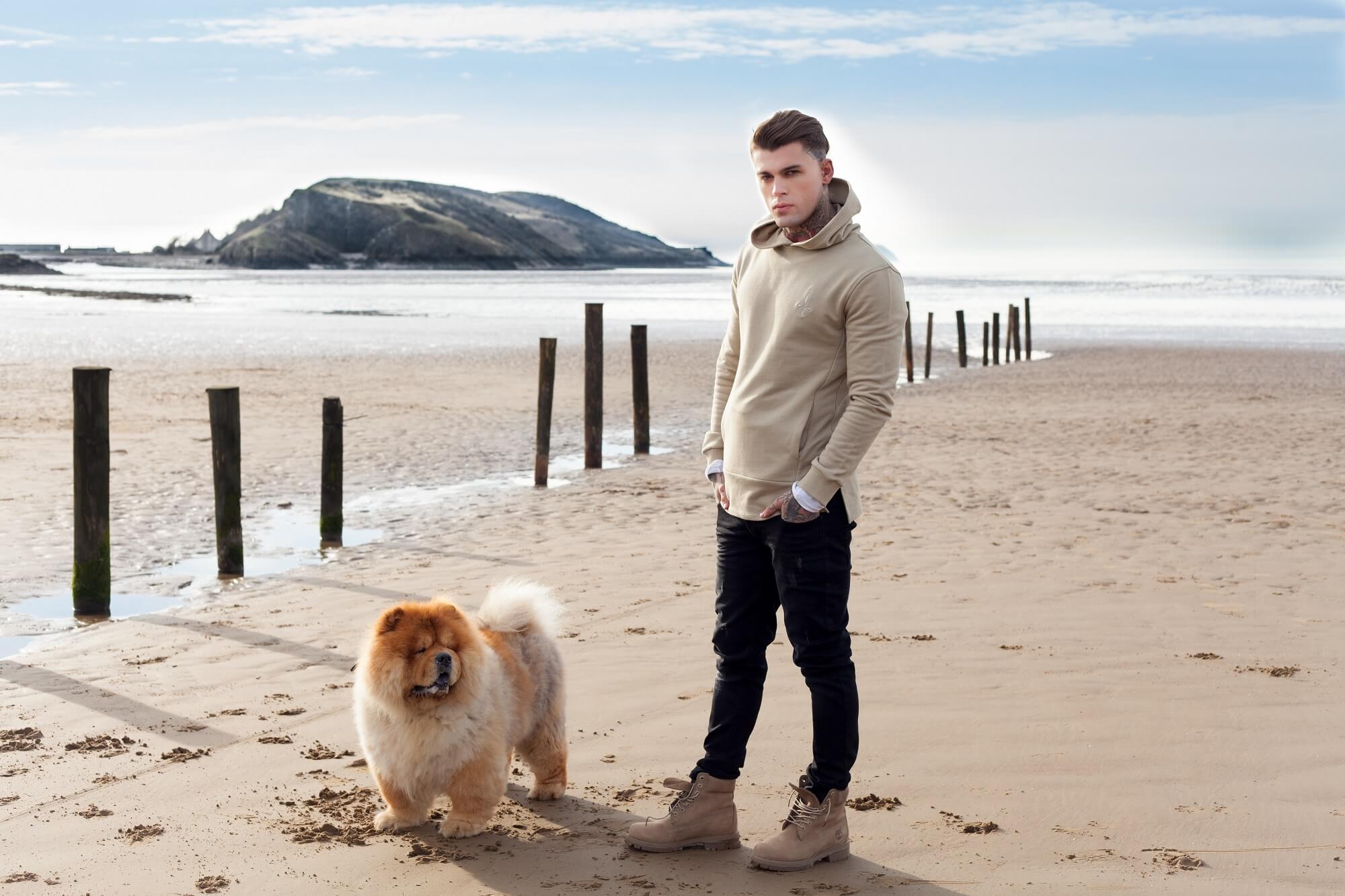 model on a beach with a fluffy dog